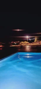 Ατμοσφαιρικό βραδινό μπάνιο στην πλήρως φωτισμένη ιδιωτική πισίνα της βίλας.