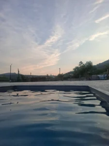 Γαλήνιο σούρουπο δίπλα στην πισίνα της βίλας μας, ιδανικό για χαλάρωση με θέα το βουνό.