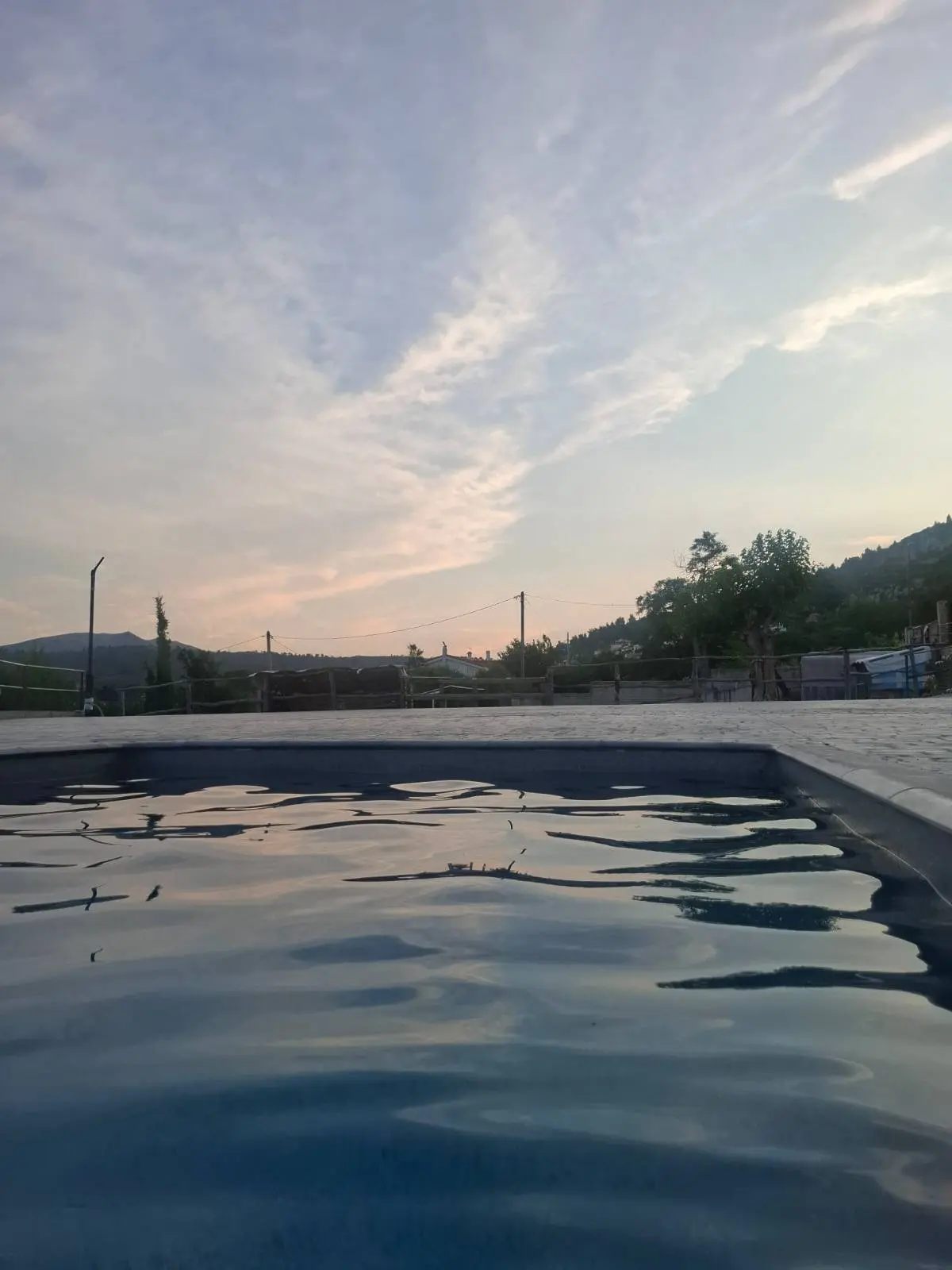 Γαλήνιο σούρουπο δίπλα στην πισίνα της βίλας μας, ιδανικό για χαλάρωση με θέα το βουνό.